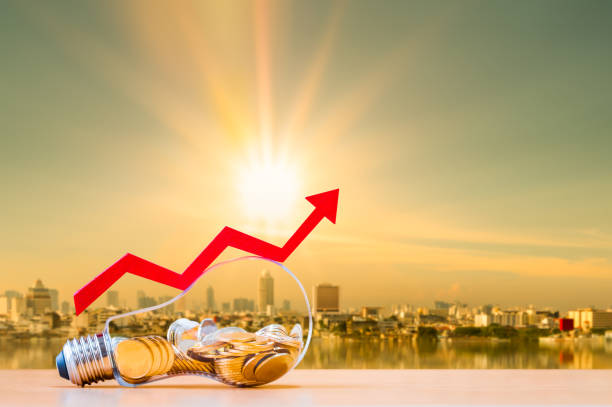 pièce de monnaie dans la bouteille d’ampoule et graphique flèche avec l’argent de valeur croissante mis sur le bois sur photo flou paysage urbain sur fond de lumière du soleil, investissement commercial et concept d’économie d’énergie. - tax collection photos et images de collection