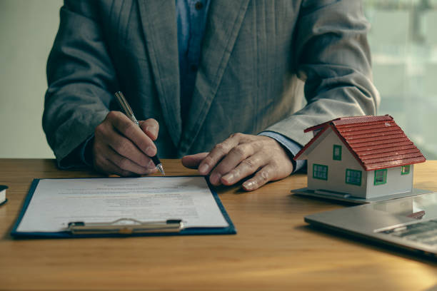 istock Real estate office businessman working with contract documents to offer clients with interest rates, home buying and insurance ideas. 1389307290