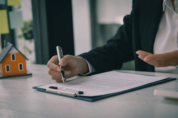 istock Real estate office businessman working with contract documents to offer clients with interest rates, home buying and insurance ideas. 1389307305
