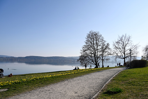 Radolfzell, Germany, March 27, 2022 - Lake promenade in Radolfzell at Lake Constance, some unidentified people in the background