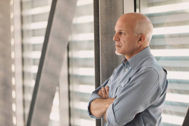 istock Middle-aged man leaning against a modern stained glass 1389310084