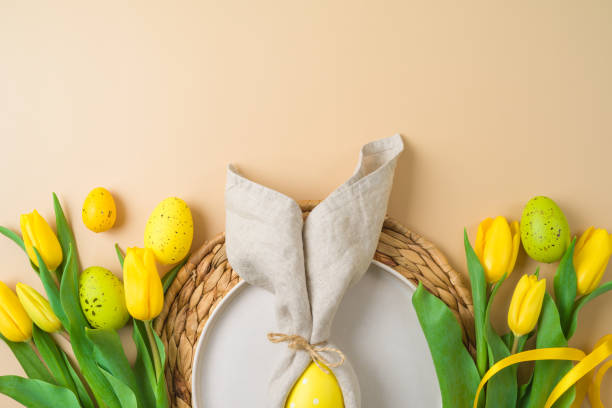istock Flay lay Easter composition with plate, easter eggs decoration and yellow tulips flowers on modern background. Top view 1389314512