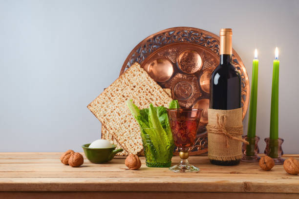 koncepcja żydowskiego święta paschy z winem, macą i talerzem sederowym na drewnianym stole na szarym tle. tradycyjny baner do nakrycia stołu pesah - passover matzo wine wine bottle zdjęcia i obrazy z banku zdjęć