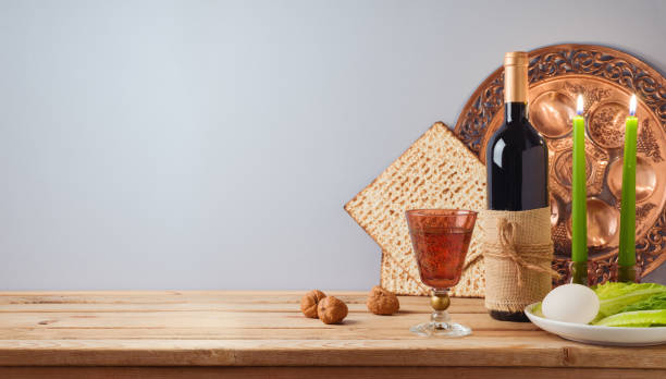 koncepcja żydowskiego święta paschy z winem, macą i talerzem sederowym na drewnianym stole na szarym tle. - passover matzo wine wine bottle zdjęcia i obrazy z banku zdjęć