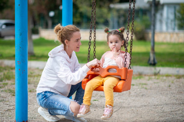 istock Unhappy baby swinging on swing. 1389316500