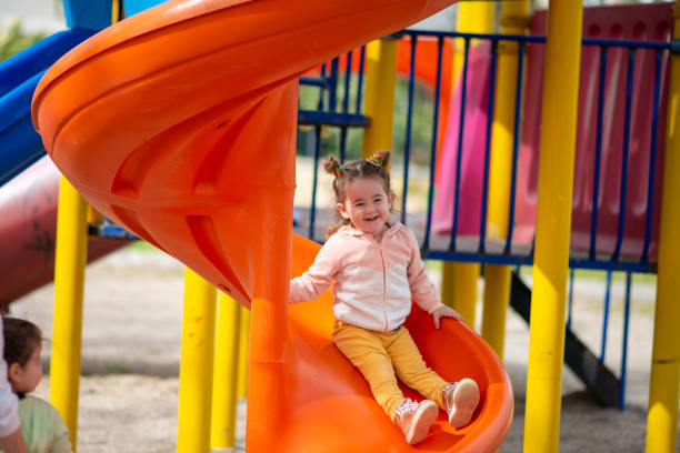 happy baby glisse sur le toboggan dans le parc - inflatable slide sliding child photos et images de collection