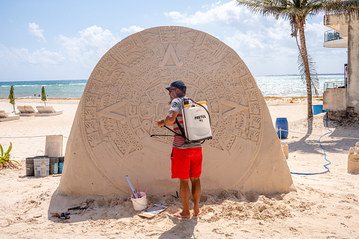 Playa del Carmen, Mexico - March 28, 2022: View of a person creating a sand sculpture in Playa.