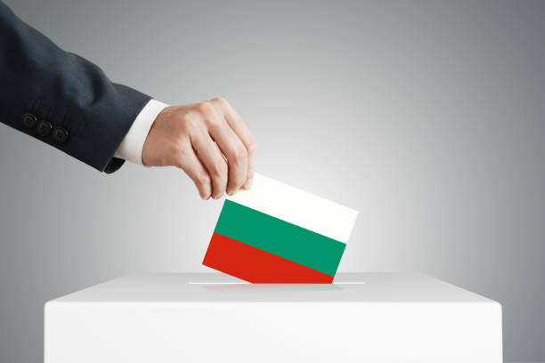 istock Man putting a ballot into a voting box. 1389317878
