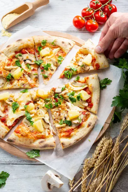 Photo of Overhead view of chicken and pineapple pizza sliced food
