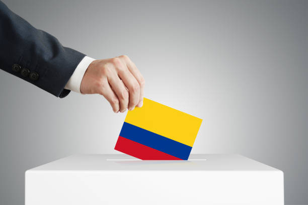 istock Man putting a ballot into a voting box. 1389318102