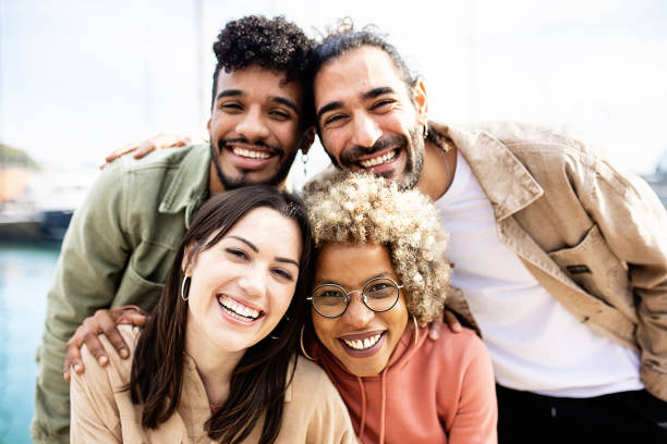 group portrait of four multiracial united friends outdoors - grupo pequeno de pessoas imagens e fotografias de stock