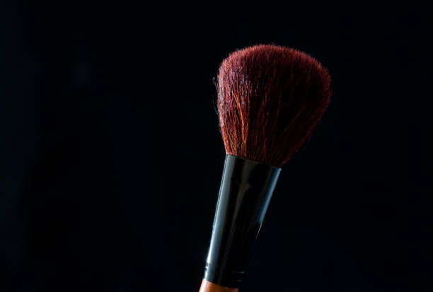 make-up brush with powder of different colors on a dark background like space dust best in Ukraine