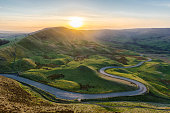 istock Sunset at Mam Tor in the Peak District with long winding road leading through valley. 1389327478