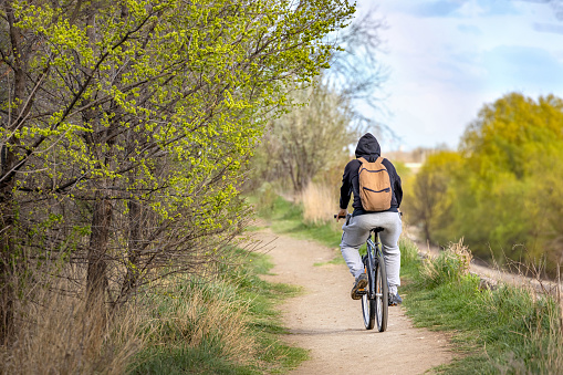 Man riding bike in nature in early spring. Vacaresti Delta, Bucharest, Romania.