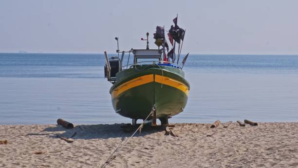 statek rybacki ze sprzętem rybackim purse sein zaparkowany na plaży sand at seashore na calm dayse seiner - ship industrial ship fishing boat europe zdjęcia i obrazy z banku zdjęć