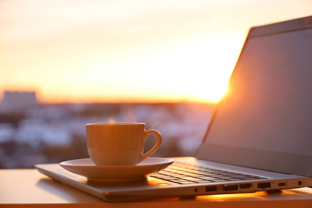 istock Coffee or tea cup on laptop against the window in sunshine 1389328710