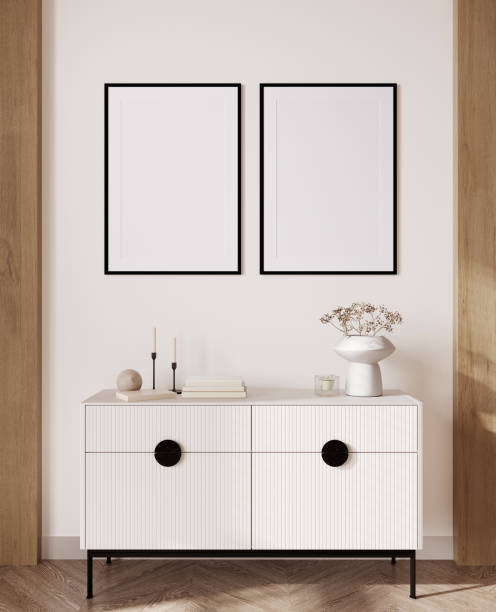 istock 3d render of a modern mockup interior with black frames on beige wall with white sideboard and a vase with small flowers. 1389328786