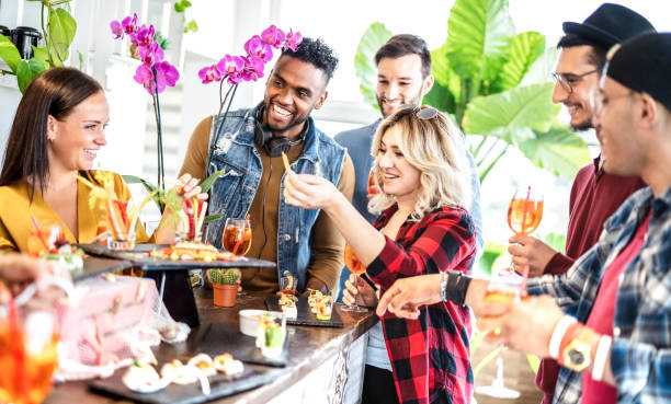 istock Multiracial trendy friends having fun at fancy dinner party on aperitif buffet drinking cocktails and eating snacks - People life style concept on happy hour together at home - Bright vivid filter 1389331184
