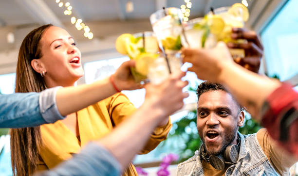 istock Trendy people toasting mojito drinks at rooftop cocktail bar - Life style concept with multiracial friends having fun drinking on happy hour at fancy pub - Vivid bright filter with focus on guy face 1389331239