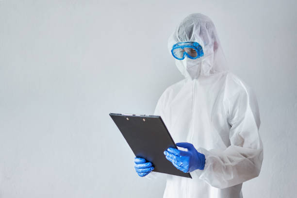 istock Portrait of a worker with full protective suit holding a folder 1389332806
