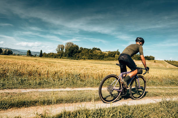 cyclist with gravel bike in italy in the countryside cyclist with gravel bike in italy in the countryside cycling vest photos stock pictures, royalty-free photos & images