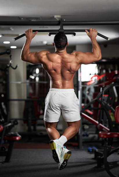 Man doing pull-ups in the gym stock photo