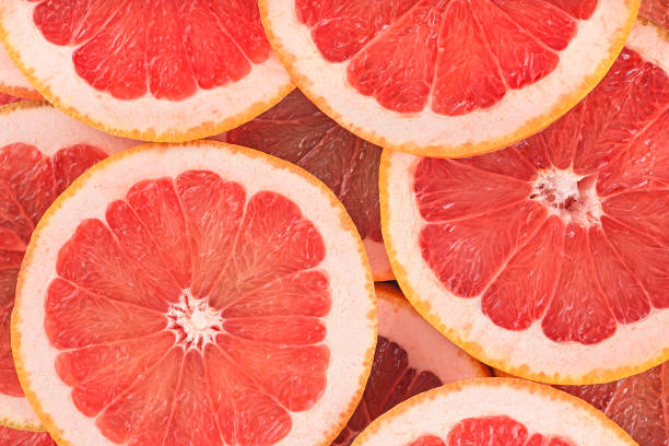 Food background - Texture of a ripe grapefruit slices, closeup. Grapefruit background. Food background - Texture of a ripe grapefruit slices, closeup. Grapefruit background. grapefruit stock pictures, royalty-free photos & images