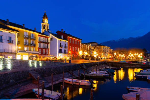 Townscape of Ascona, Switzerland. View of Lake Maggiore, embankment and Church of Saints Peter and Paul in evening.