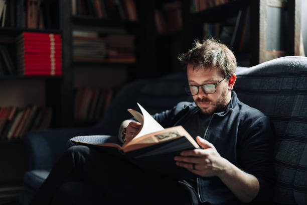 istock Adult student reading a book in the college library 1389338518
