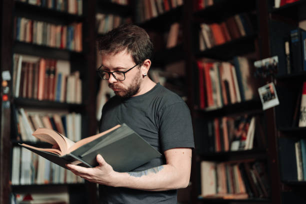 istock Adult student reading a book in the college library 1389338522
