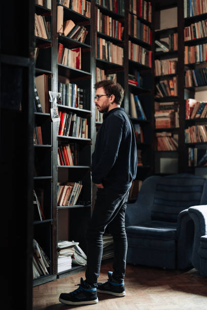 istock Adult student watching for a book in the college library 1389338533