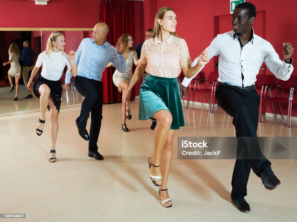 Couples enjoying boogie-woogie Adult dancing couples enjoying active boogie-woogie in modern studio 20-24 Years Stock Photo