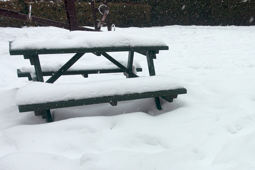 Snow covered picnic tables in the park at winter