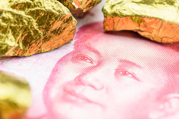 metalli preziosi e concetto di investimento in valuta: minerale di ferro color oro su un denaro yuan cinese. - finance china stock exchange shenzhen foto e immagini stock