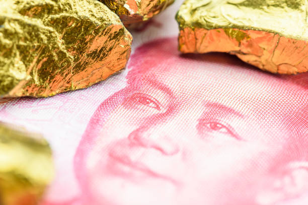 precious metals and currency investment concept : gold colored iron ore on a china yuan money. - stock market china shenzhen asia imagens e fotografias de stock