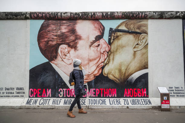kiss alla east side gallery - east germany berlin germany graffiti wall foto e immagini stock