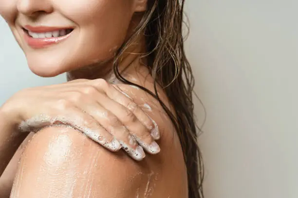 Young sensual woman washing her body with shower gel