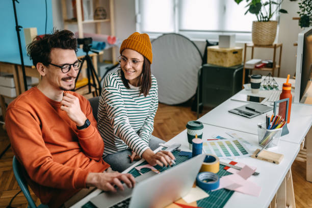 istock Smiling professionals discussing over laptop in studio 1389344751