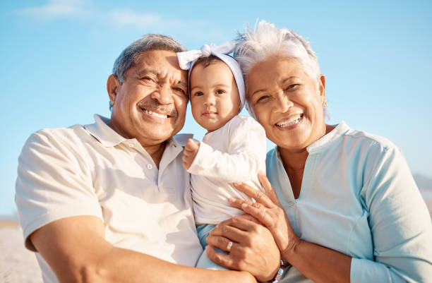 彼らの愛らしい孫娘とビーチでシニアカップルのショット - 祖父母 ストックフォトと画像