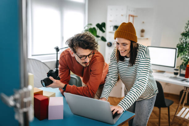 istock Businessman standing with coworker using laptop on table 1389345937