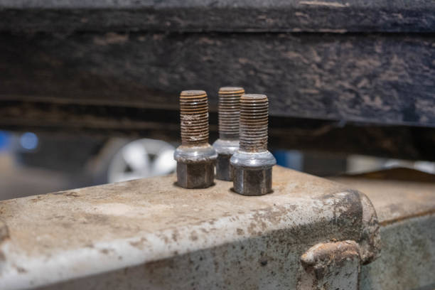 istock Screw out three car wheel bolts set together 1389348777