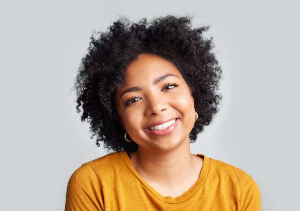 istock Studio shot of a beautiful young woman smiling while standing against a grey background 1389348876