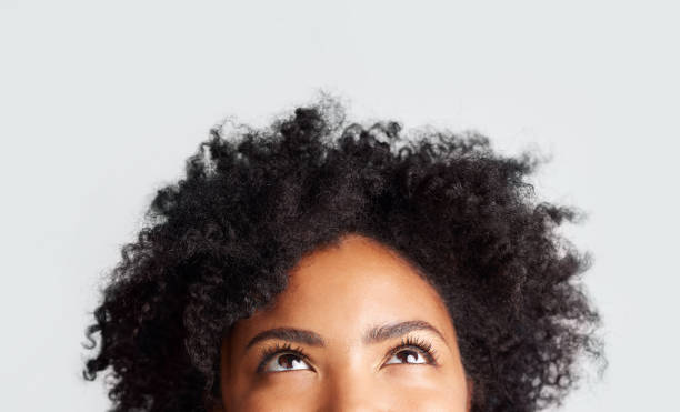 plan recadré d’une femme regardant debout sur un fond gris - coiffure afro photos et images de collection