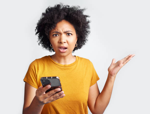 istock Shot of a young woman looking frustrated while using her cellphone 1389349402