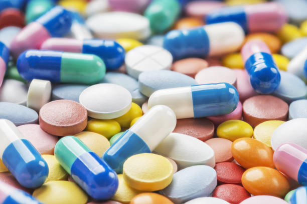 таблетки. фармацевтические препараты от гриппа, вич, гипертонии и других заболеваний. - pill multi colored capsule nutritional supplement стоковые фото и изображения