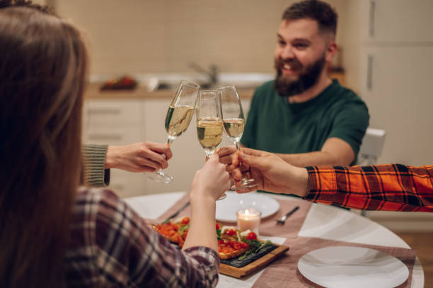 istock Friends sitting at a kitchen table and toasting during a dinner part 1389349921