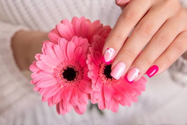istock Female hands with pink manicure, flowers design 1389351079