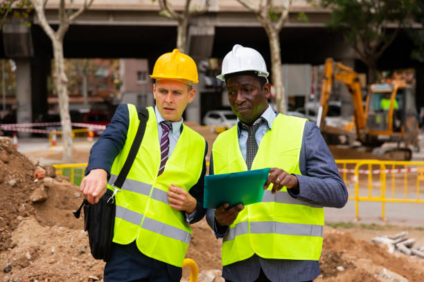 istock Architect tells engineer where to dig a trench to lay pipe 1389352302