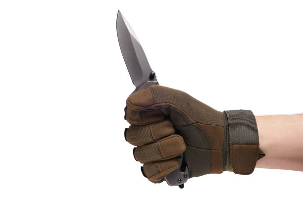 istock Hand in tactical glove, holding folding knife, on white background. 1389353303