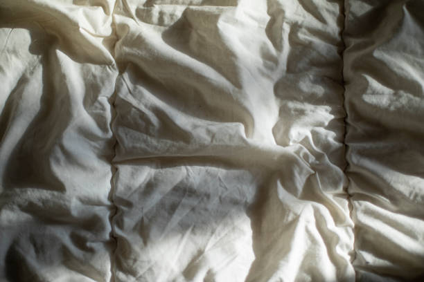 istock Matting sheet on bed. Texture of fabric in sunlight. 1389353350
